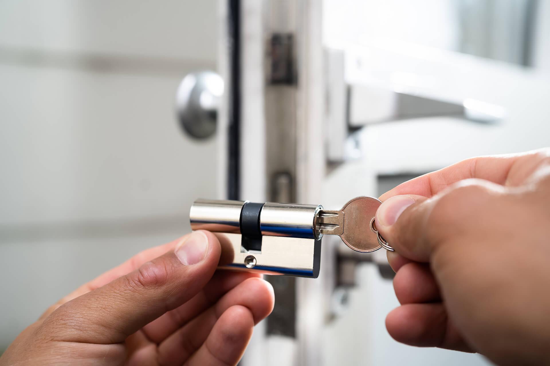 A locksmith rekeying a commercial door lock to enhance business security and access control. A locksmith rekeying a commercial door lock to enhance business security and access control.