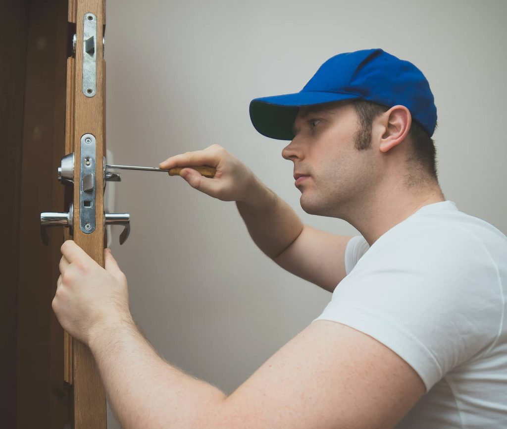 Locksmith Northyork Locksmith On Demand Young Handyman In Uniform Changing Door Lock