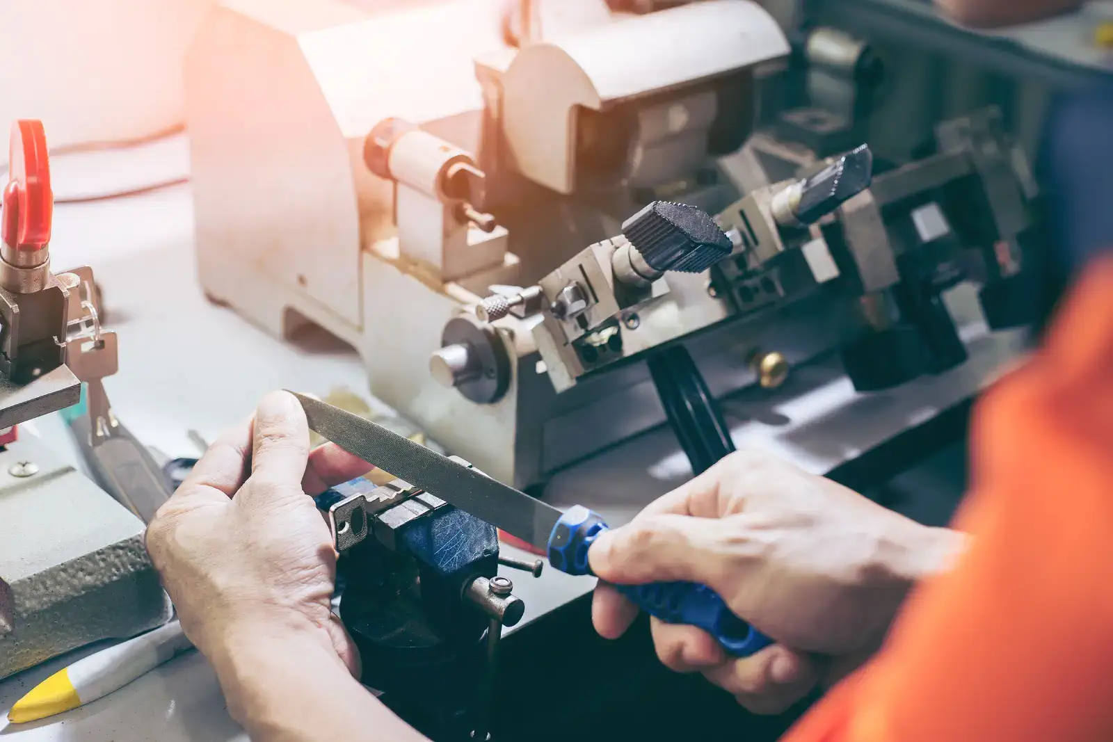 Technician performing house key duplication using a manual file – Locksmith On Demand