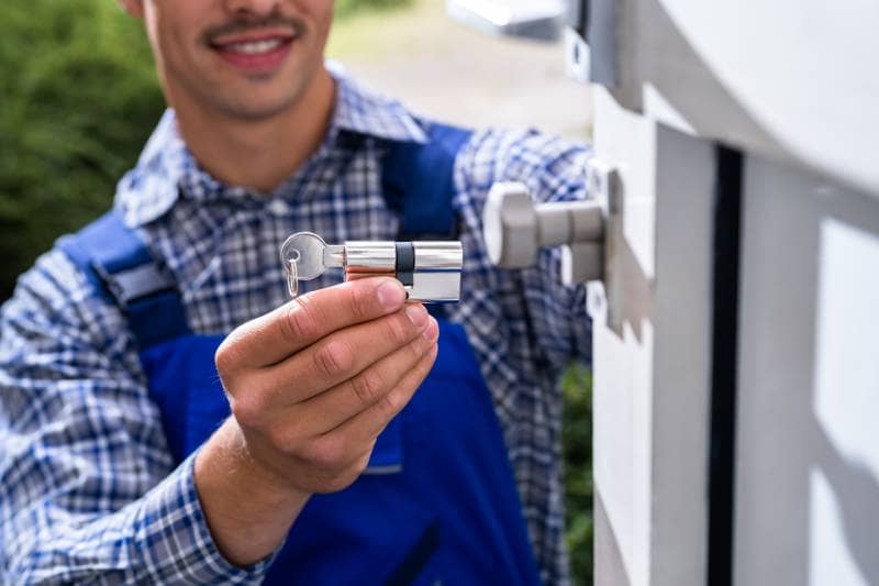 Locksmith adjusting a lock cylinder for a secure rekeying service.