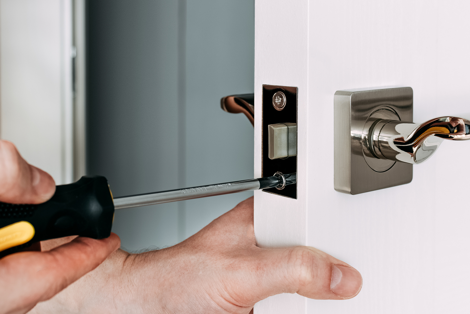 A Locksmith Repair The Door Lock In The Room. A Locksmith Fixing